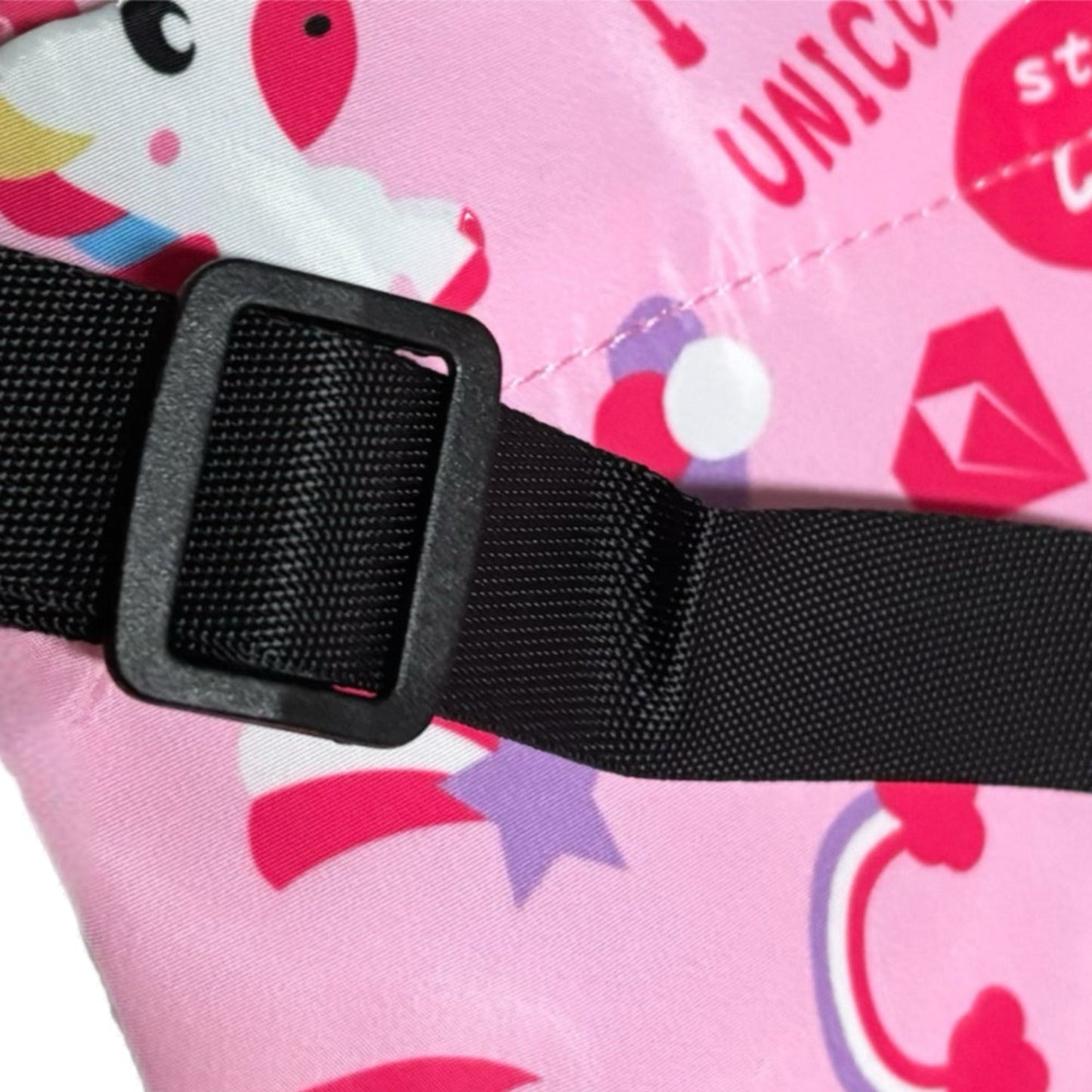 Black strap with buckle on a pink background with unicorn designs