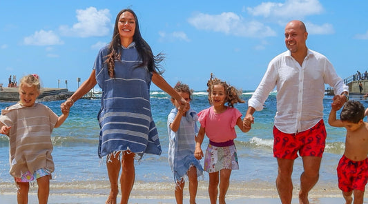 A split seasonal scene showing Australia transitioning out of summer while the United States enters summer beach season around Memorial Day, with families enjoying outdoor activities and beachwear.