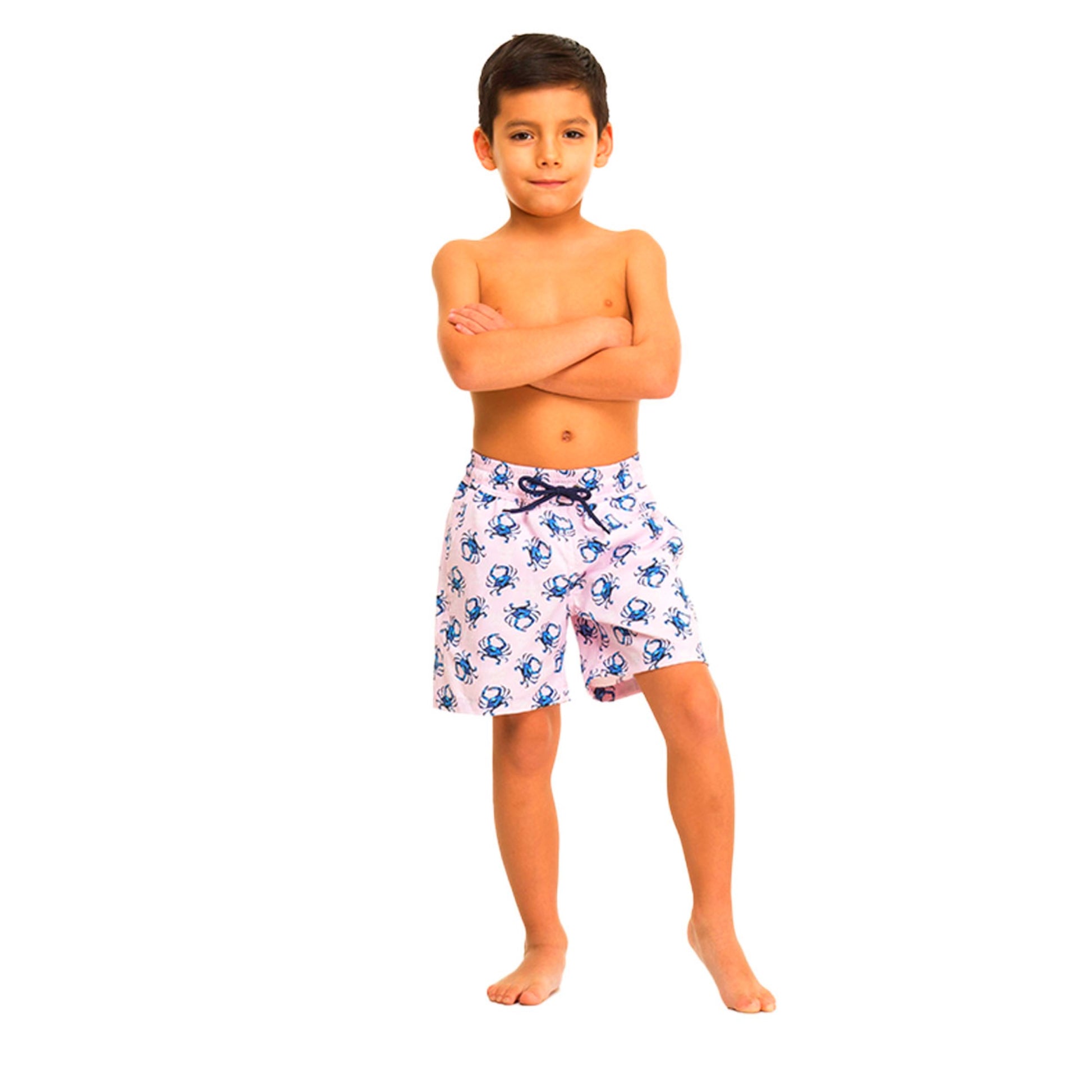 Young boy wearing a pink swimsuit with crabs on a white background