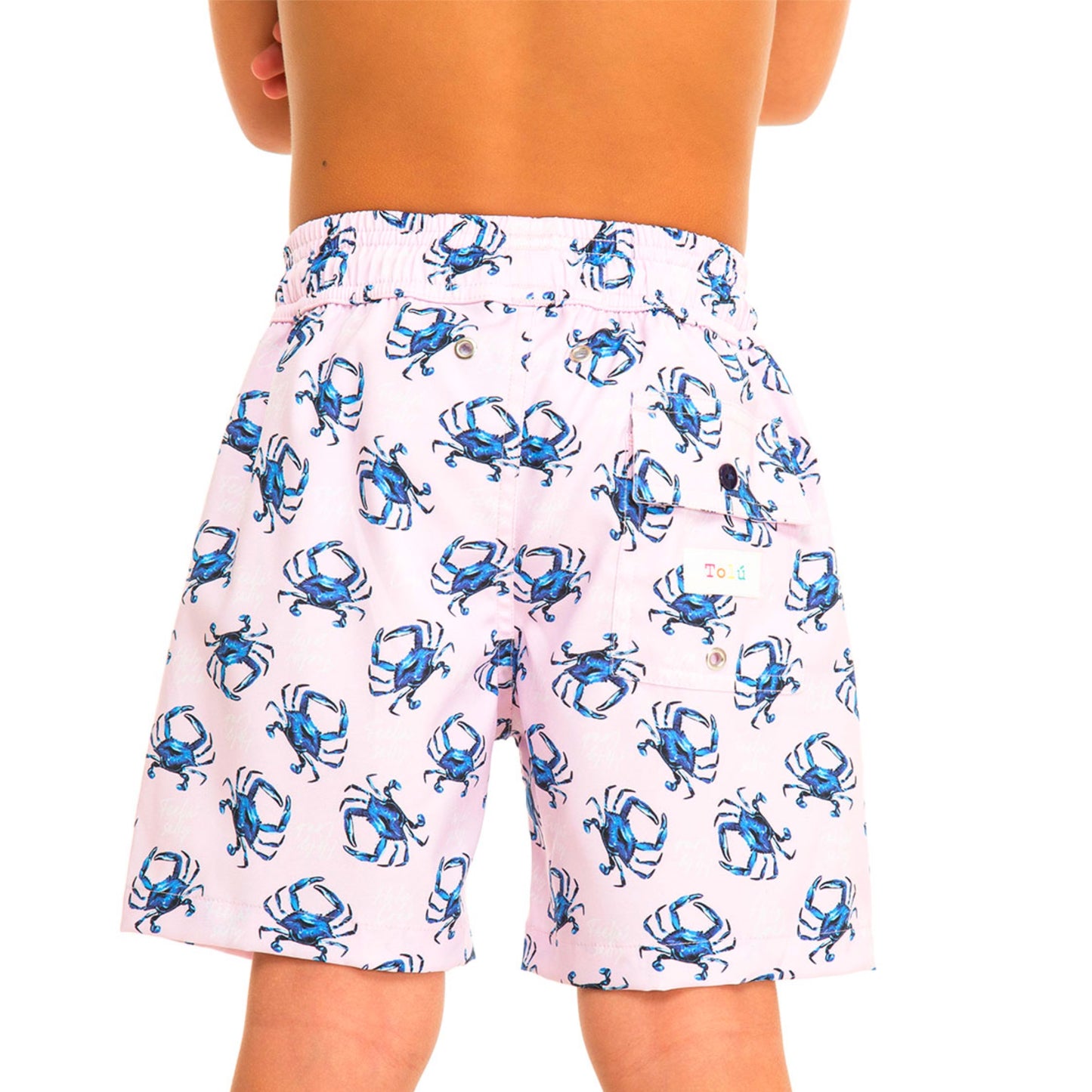 pink swim shorts with blue crab pattern worn by a boy on a white background