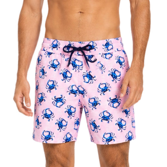 Pink swim shorts with blue crab pattern worn by a person on a white background